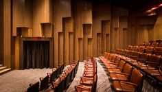 an empty auditorium with brown leather seats