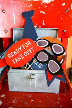 a red chair with a sign that says ready for take off? and sunglasses on it