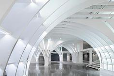 an empty building with white walls and arches