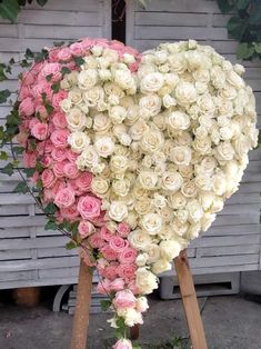 a heart shaped arrangement of white and pink roses