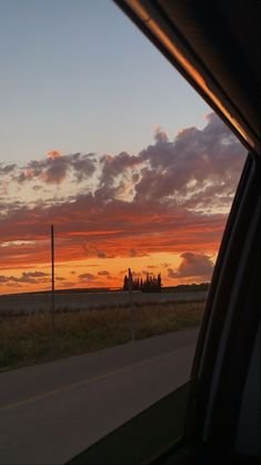 the sun is setting over an open field