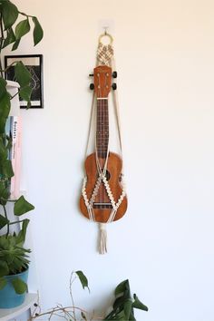 a wooden instrument hanging on the wall next to a potted plant in a room