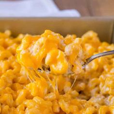 a spoonful of macaroni and cheese being lifted from a casserole dish