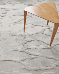 a wooden table sitting on top of a carpet covered in lots of white circles and shapes