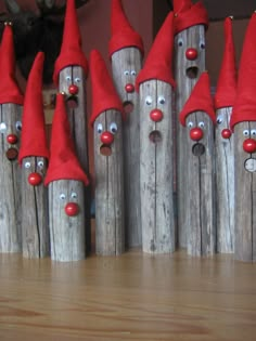 several wooden posts with red hats and noses on them, all lined up in rows