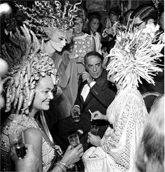 an old black and white photo of people dressed in fancy garb at a party