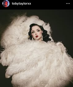 a woman in a white fur coat posing for the camera