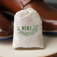 a bag with the word mint on it sitting next to some shoes and one shoe