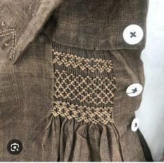 the back of a dress with buttons on it and some holes in the front pocket