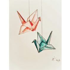 two origami cranes hanging from strings