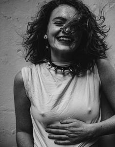 black and white photograph of a woman with her hair blowing in the wind, smiling