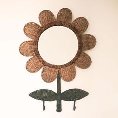 a decorative flower made out of wicker hanging on the side of a white wall