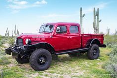 an old red pick up truck parked in the desert