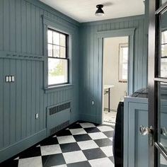 an empty room with blue walls and black and white checkered floor