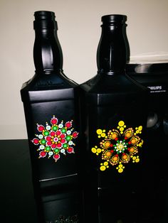 two black bottles with colorful designs on them