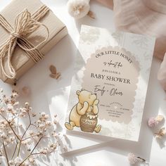 a baby shower book with a teddy bear on it next to a gift box and flowers