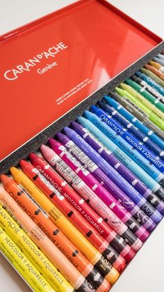 a red box filled with lots of different colored crayons