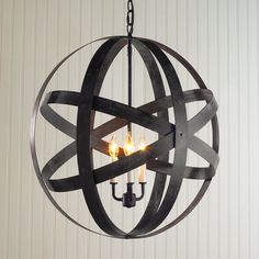 an orb chandelier with three candles in the center and one candle lit inside