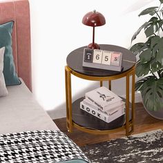 a small table with books on it next to a bed and a plant in the corner