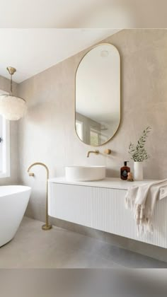 a bathroom with two sinks, a bathtub and a large mirror on the wall