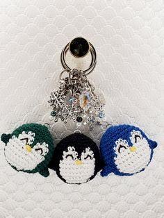 three crocheted keychains are sitting next to each other on a white surface