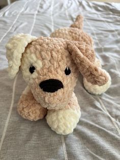 a stuffed dog sitting on top of a bed