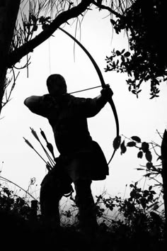 the silhouette of a man holding a bow and arrow