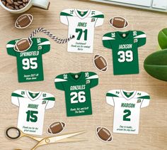 football jersey cutouts with scissors on a wooden table next to a cup of coffee