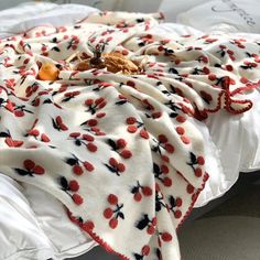 a blanket with cherries on it laying on a bed