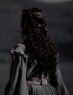 the back of a woman's head with long dark hair, wearing a black dress