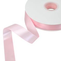 a roll of pink satin ribbon on a white background with a light pink colored edge