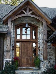 a wooden door is in front of a stone house