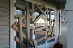 a bunch of pieces of wood sitting on top of a window sill in front of a house