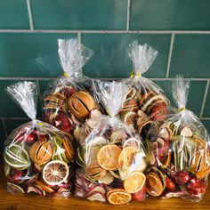 bags filled with fruit and vegetables sitting on top of a wooden table next to a tiled wall