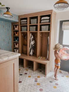 a little boy standing in the middle of a room with lots of closets and shelves