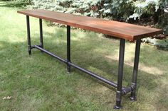 a wooden table sitting on top of a lush green field