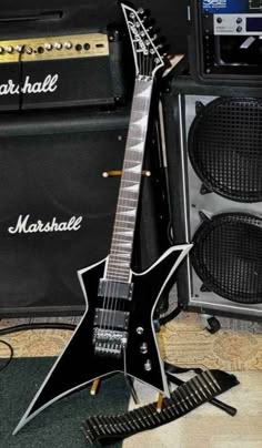 an electric guitar sitting next to two amps