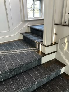 a stair case with carpeted steps leading up to a window