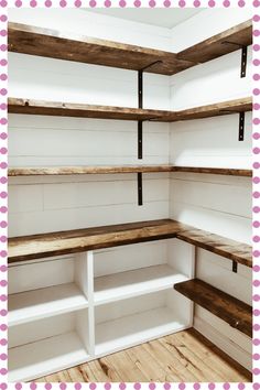 the inside of a white painted pantry with shelving and pink polka dot wallpaper