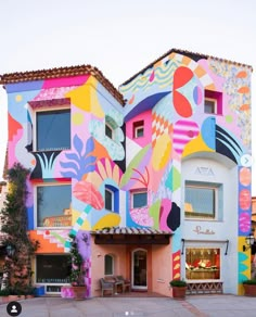 a multicolored building with an artistic mural on it's front and side