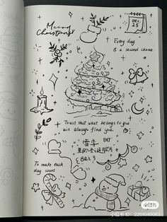 an open book with doodles and drawings on the pages, including a christmas tree