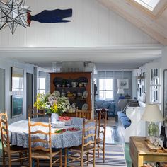 a dining room table with chairs and a blue striped rug on the floor in front of it