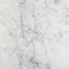 a white marble counter top with brown spots on it's edges and an orange object in the middle