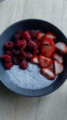 a bowl filled with oatmeal and strawberries on top of a table