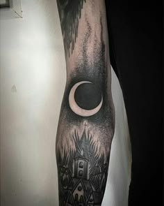 a man's arm with a black and white tattoo on it, depicting the moon