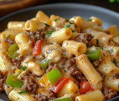 a plate full of pasta with sausage and peppers