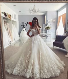 a woman taking a selfie in front of a mirror while wearing a wedding dress