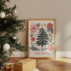 a christmas tree with presents under it in front of a framed art print on the wall