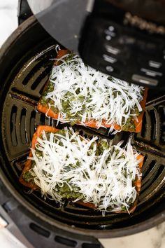 some food is cooking in an air fryer with grated parmesan cheese on top