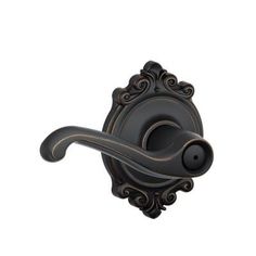 an antique style door handle in black with gold trim and scroll design on the front